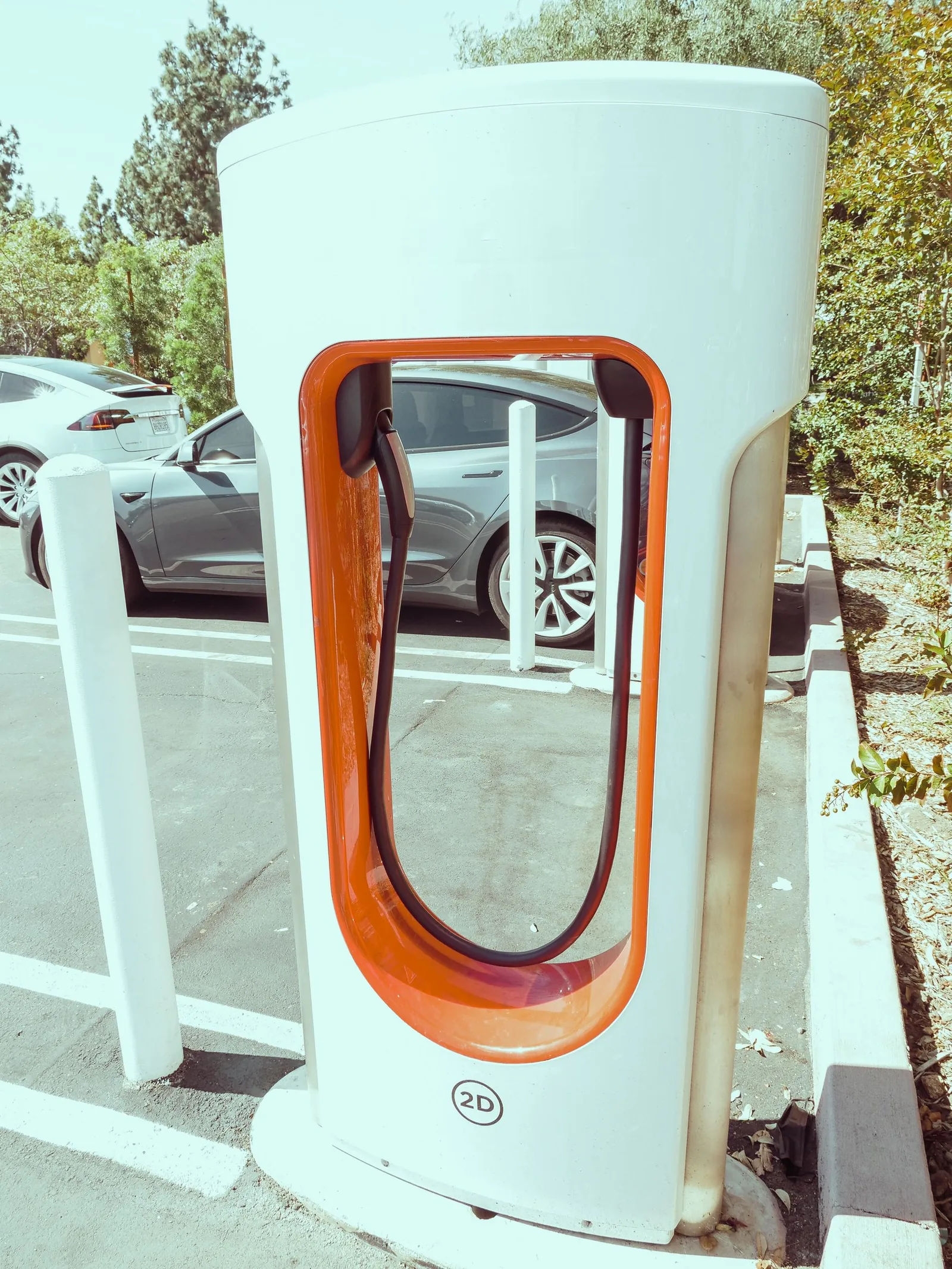 Charging unit positioned beside parked cars