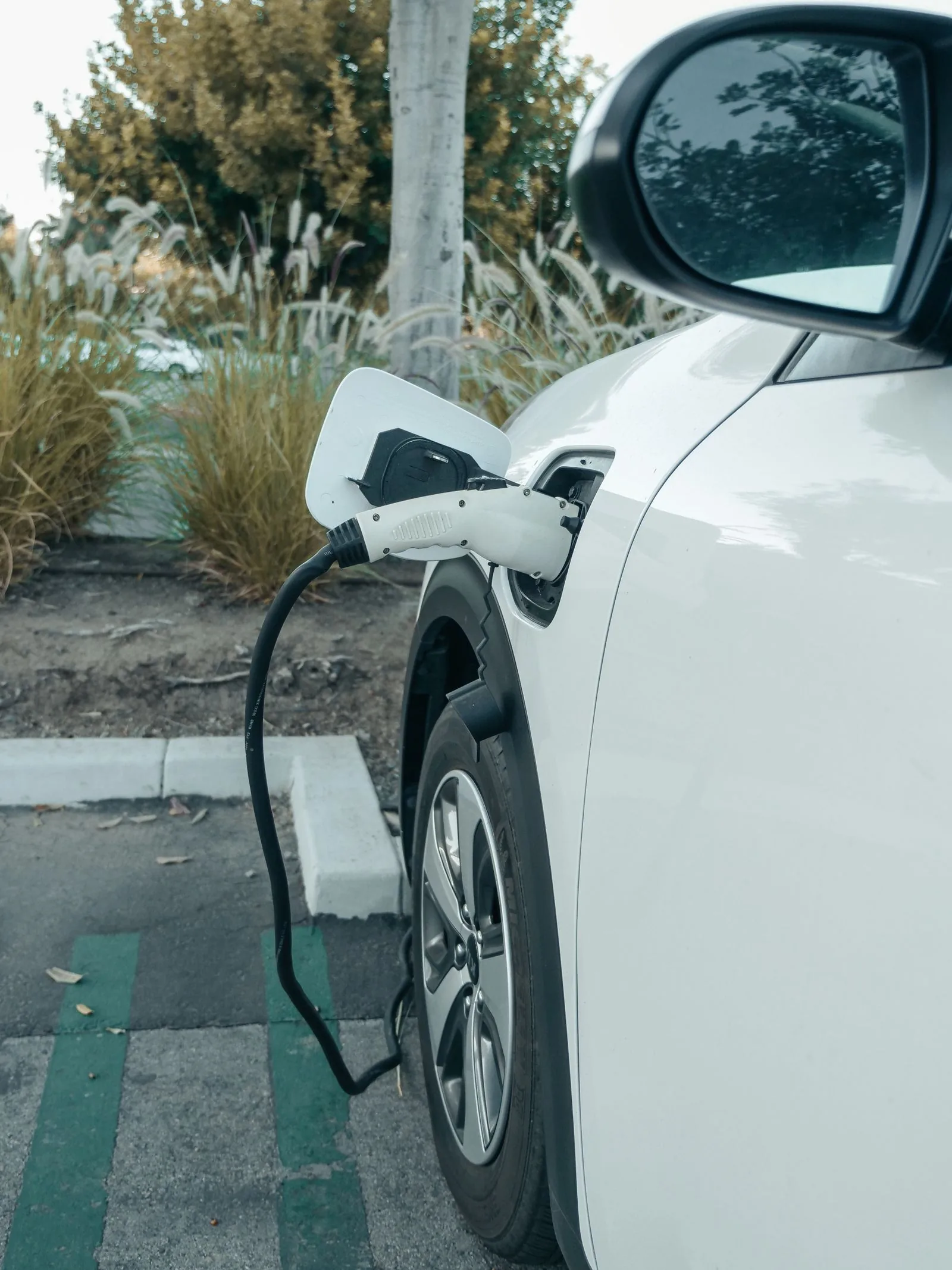 Electric car connected to a charging cable in a parking bay